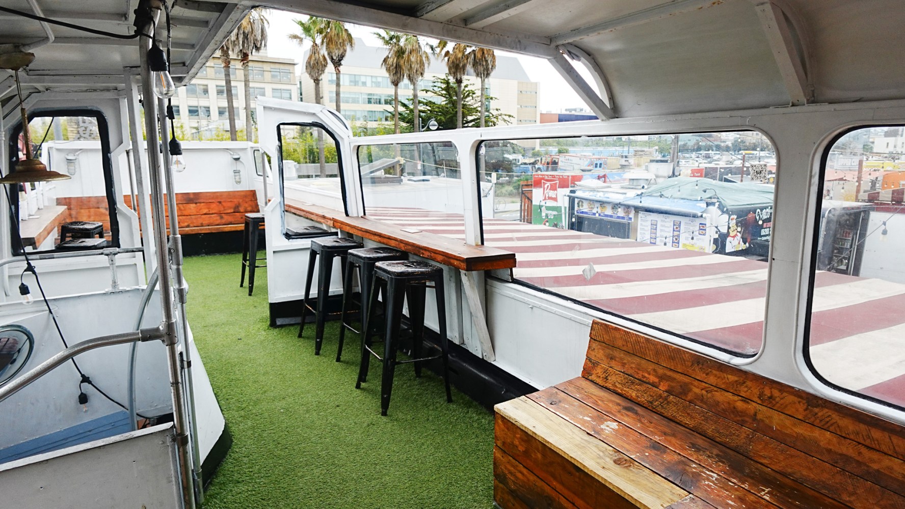 Boat deck with bar seating and artificial grass flooring.