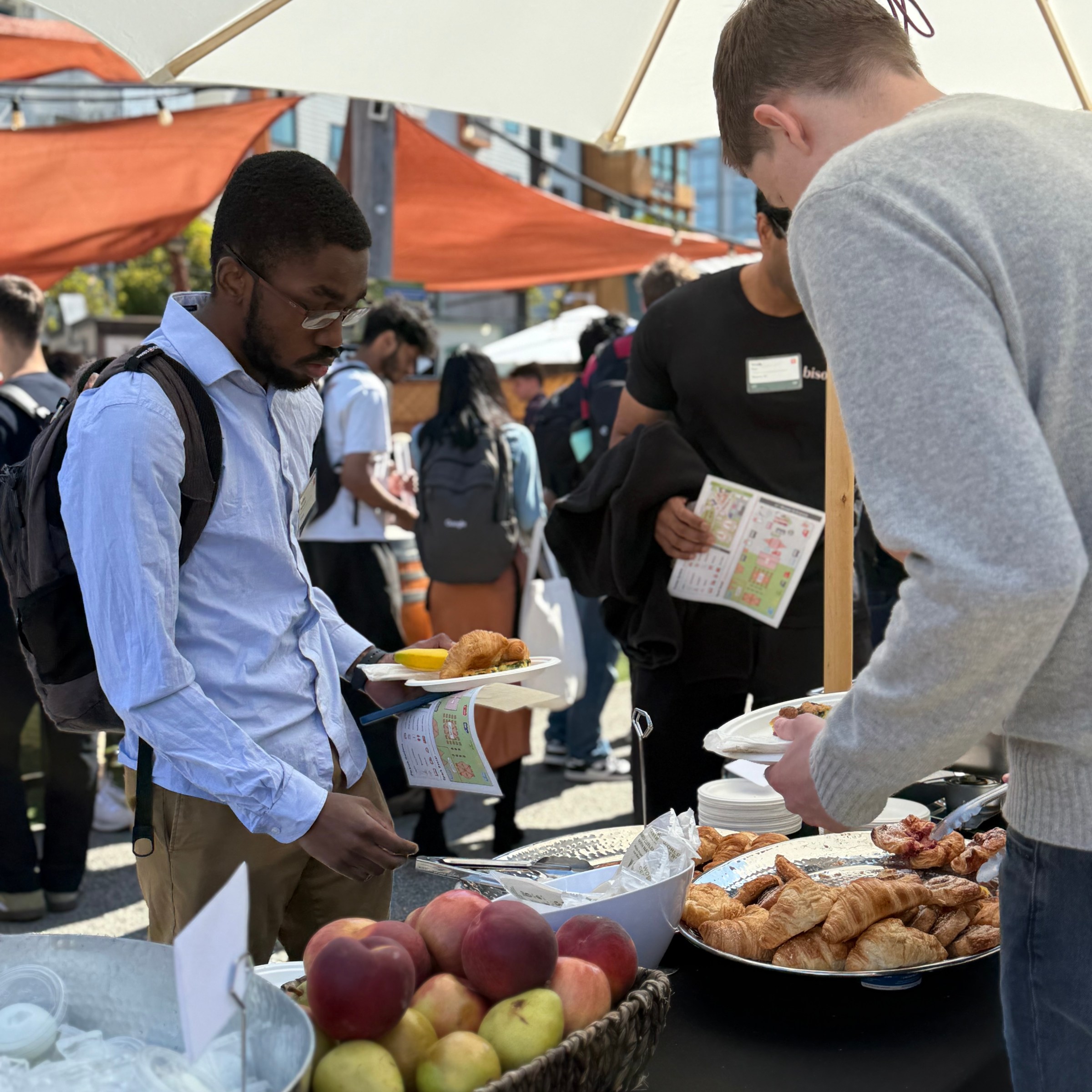 a group of people sitting at a table with food