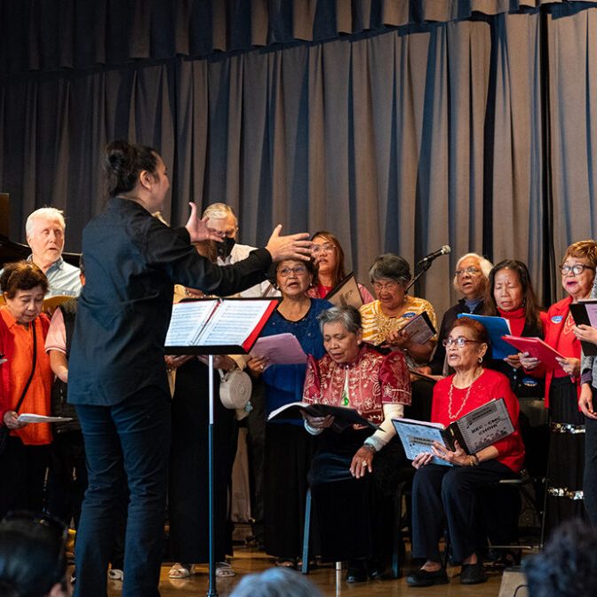 a group of people standing in front of a curtain singing