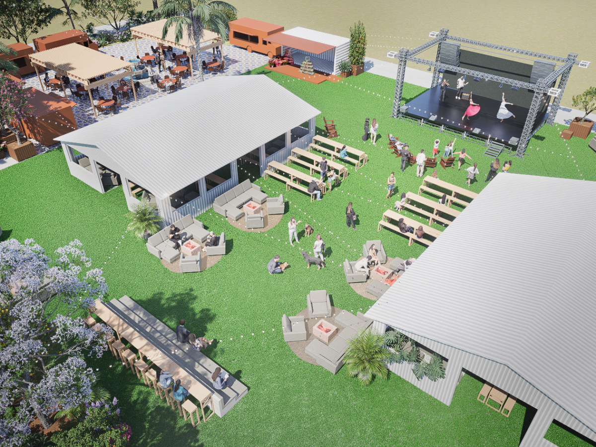 Aerial view of an outdoor event with seating, tents, and a stage on a grass area.