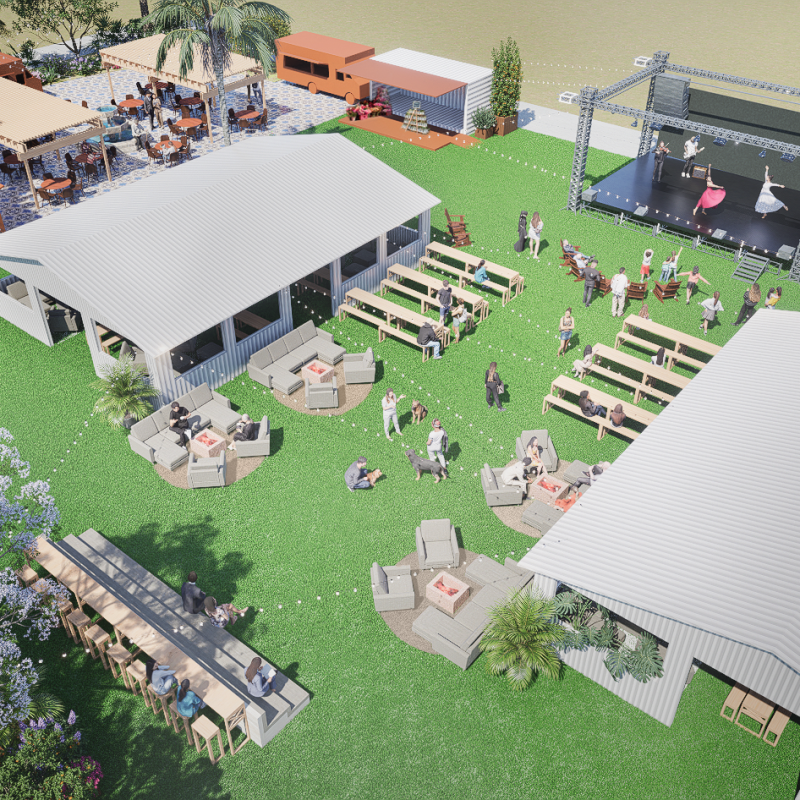 Aerial view of an outdoor event with seating, tents, and a stage on a grass area.