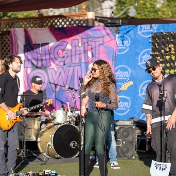 Band performing outdoors with banner reading 'Night Owl' in background.
