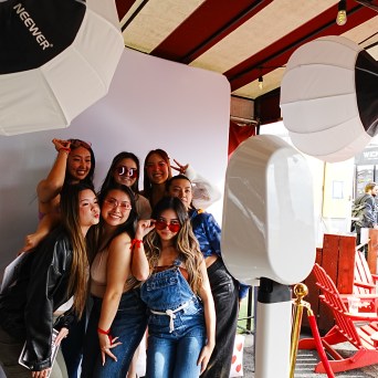 Group of people posing in photo booth with lighting equipment.
